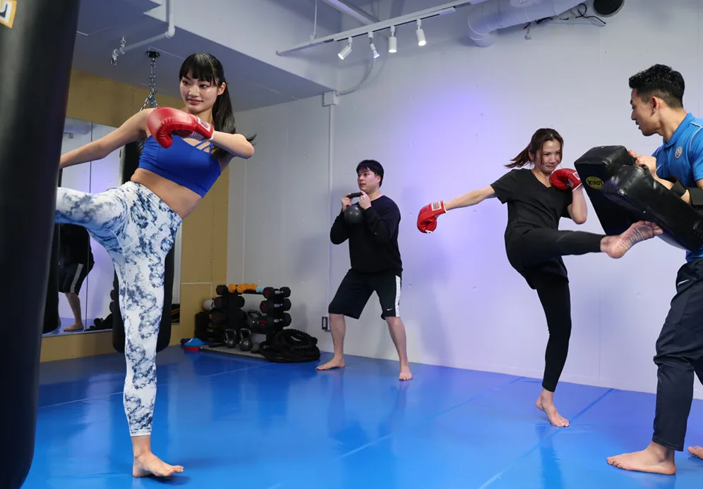 サンドバッグやミットでトレーニングする会員